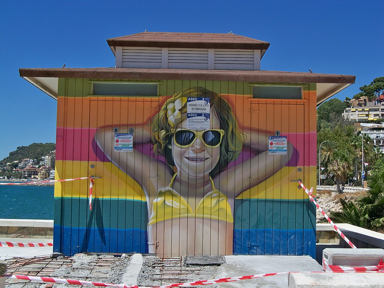 Een strandtoilet met een bordje met openingsuren voor het seizoen