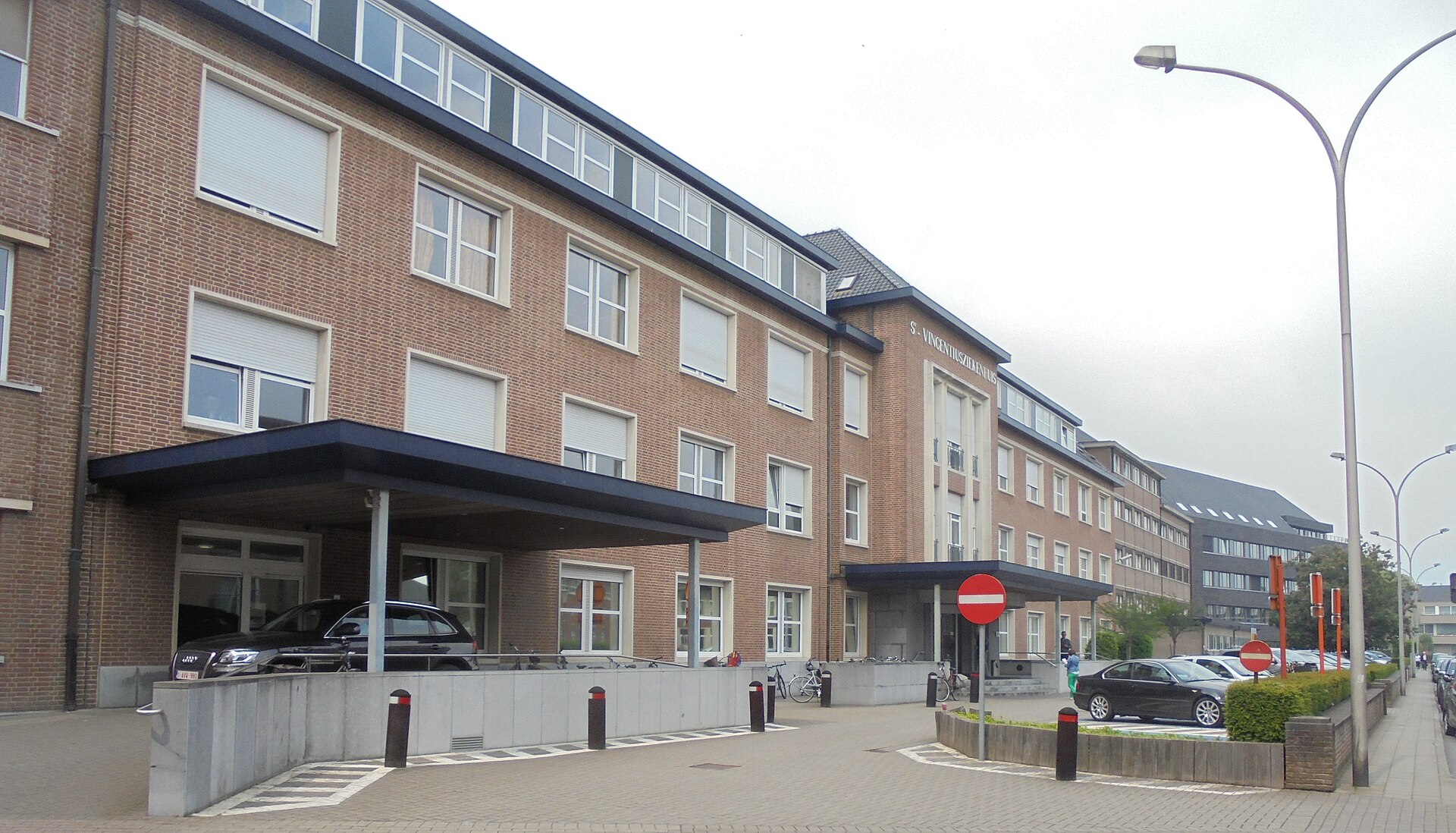 De ingang van het Sint-Vincentiusziekenhuis in Deinze, een bakstenen gebouw met een luifel boven de deur